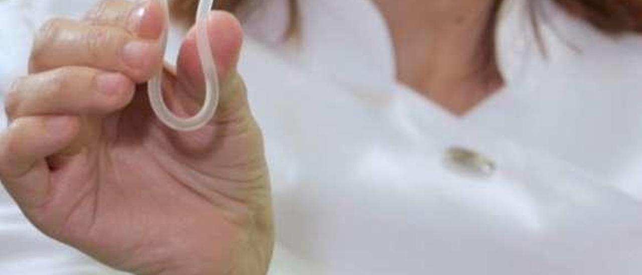 Un anillo vaginal en la mano de una enfermera y el envase de Dolna.