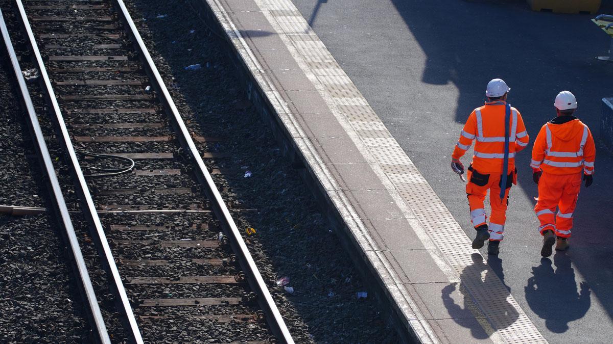 20 de junio de 2022, Reino Unido, Liverpool: Los trabajadores caminan junto a las líneas ferroviarias en la estación Hunts Cross, Liverpool. MerseyRail ha anunciado que todos los trenes se detendrán mañana debido a la acción industrial. Foto: Peter Byrne/PA Wire/dpa 20/06/2022 SOLO PARA USO EN ESPAÑA