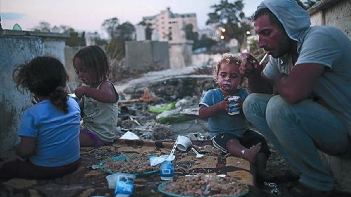 Miseria 8Una familia palestina en Gaza tras romper el ayuno del Ramadán, ayer.