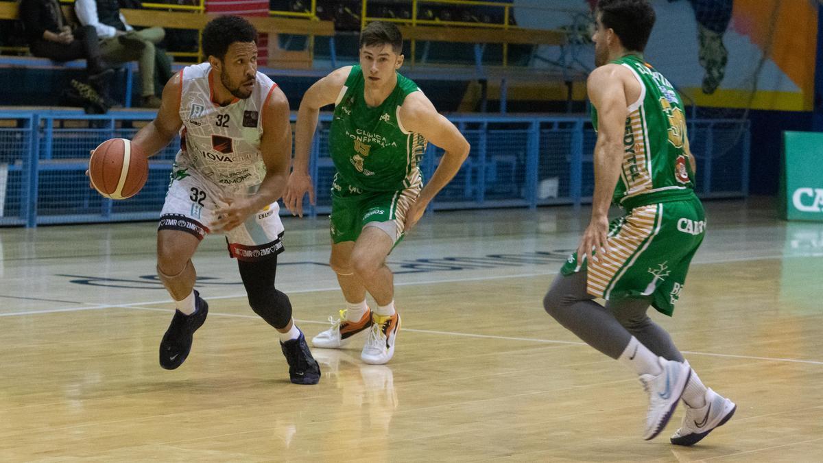 Solarin bota el balón ante dos jugadores del Clínica Ponferrada.