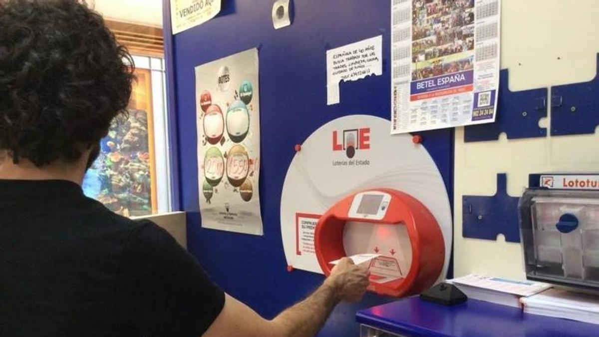 Archivo - Un apostante en una administración de loterías