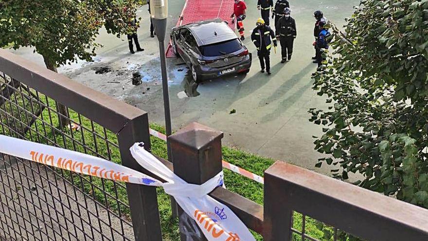 El coche en el parque siendo retirado por la grúa.