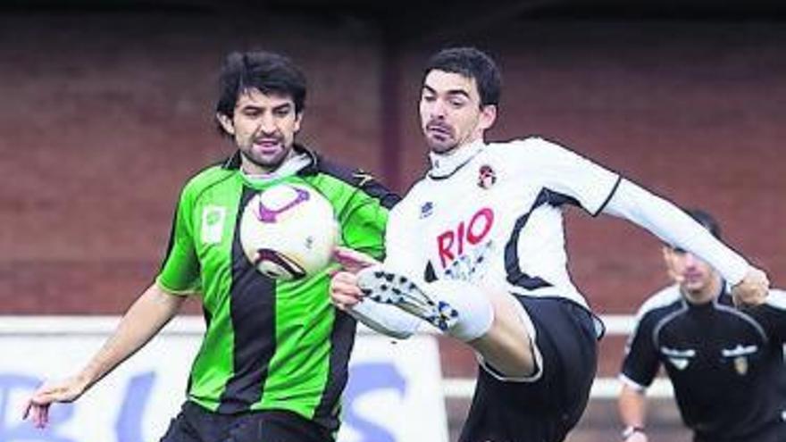 Calvillo trata de rematar a portería ante la presión de Jabuto, del Uni.