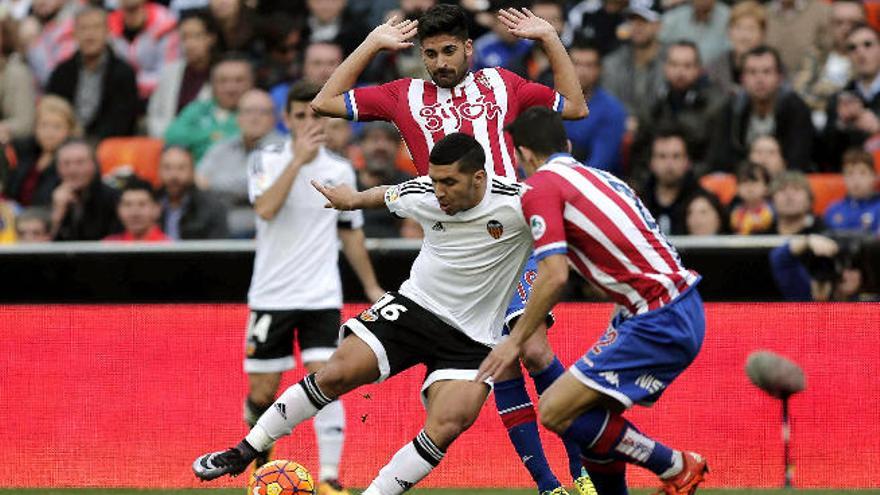 Bakkali (c) disputa un balón con varios jugadores del Sporting de Gijón.