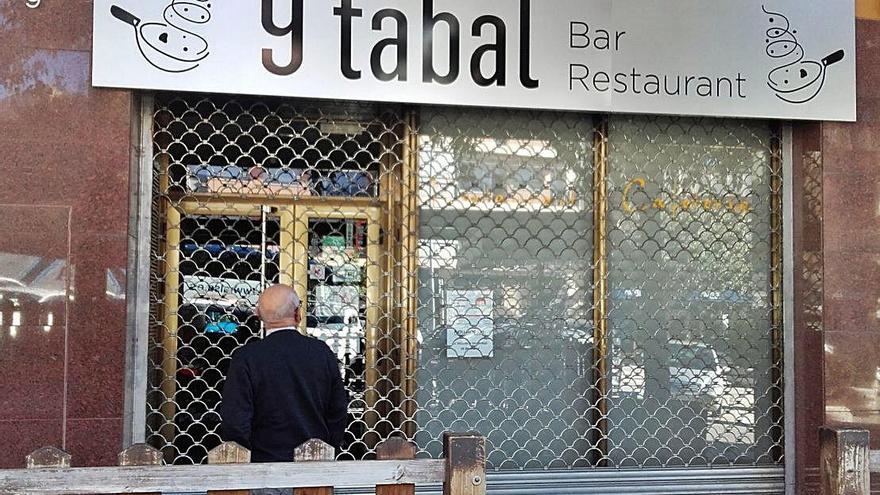 Un home mira la porta barrada del restaurant 9 Tabal de Berga