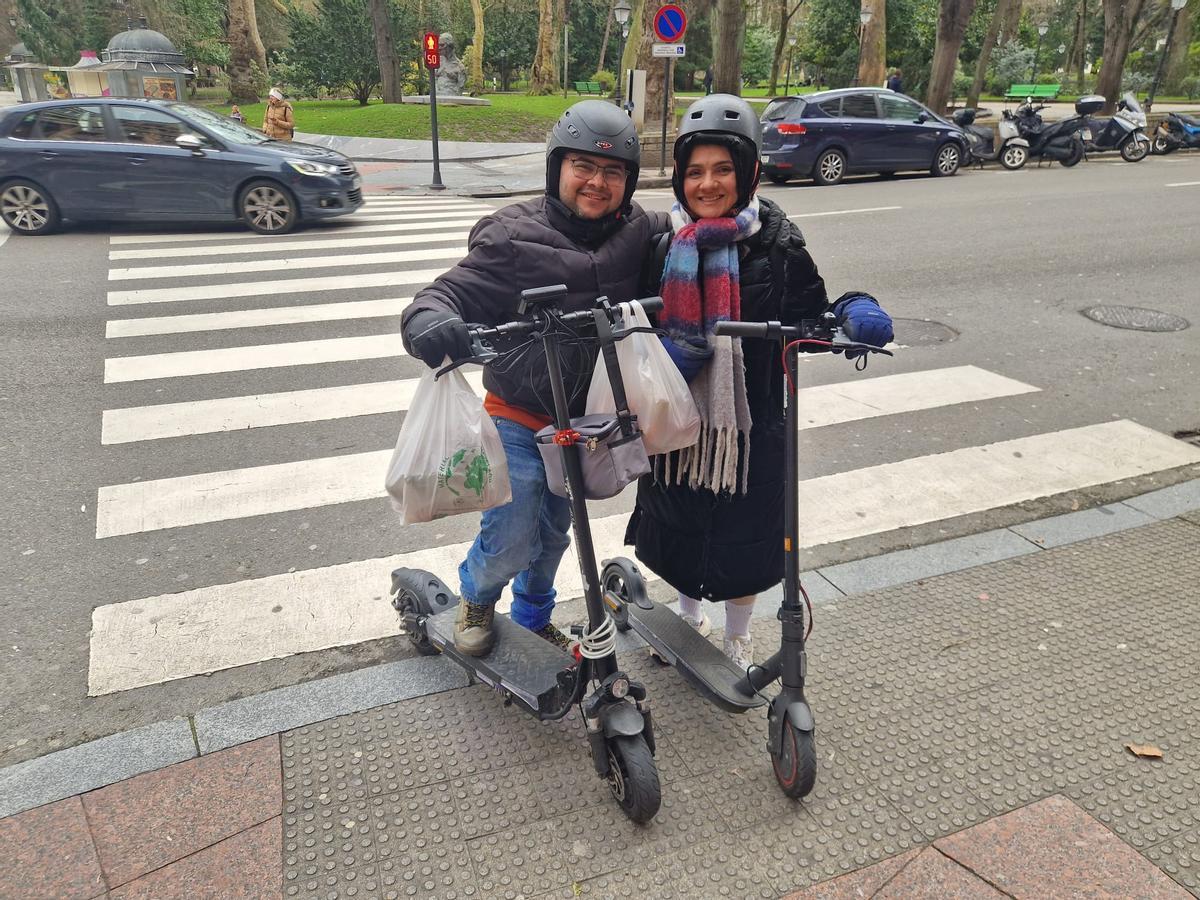 Carlos Rivera y Karla González, ayer, posando con sus patinetes entre Uría y Conde de Toreno.