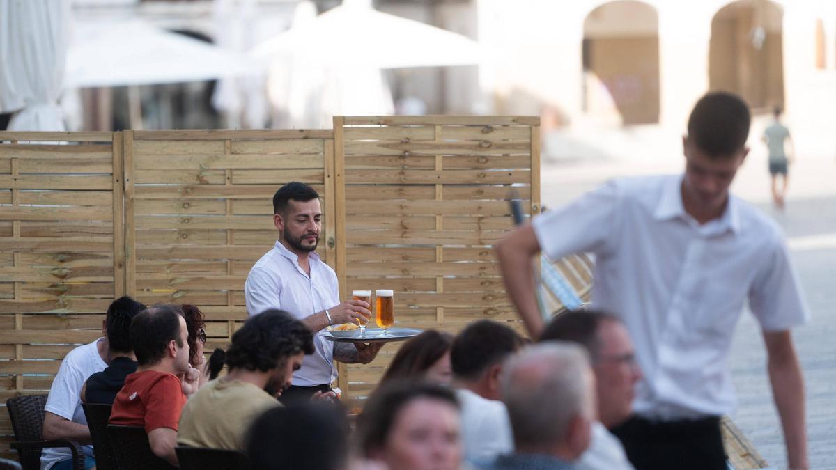 Un joven sirve dos cervezas en la plaza Mayor, este domingo por la tarde.