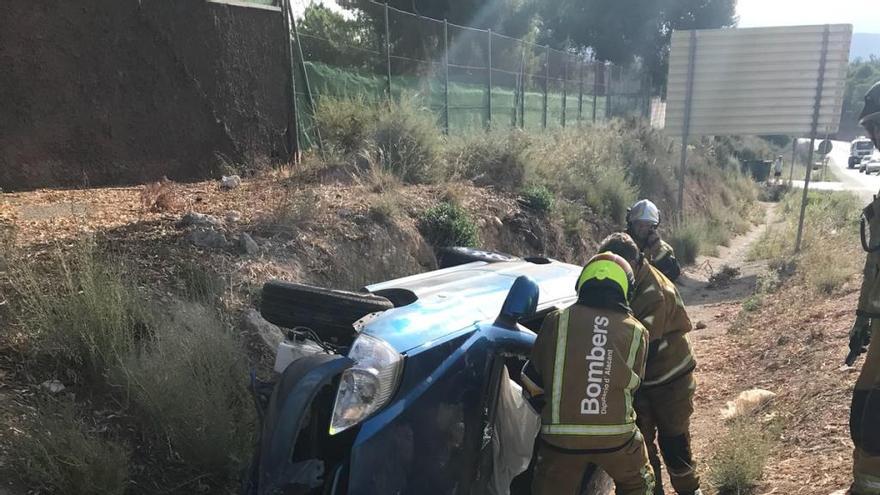 Los bomberos junto al coche que ha sufrido el accidente