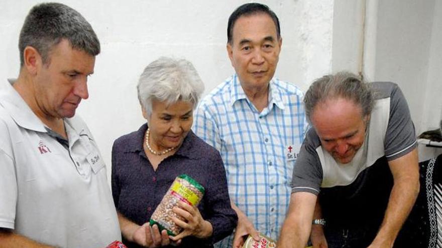 Lee Kim, junto a su mujer y dos voluntarios organizando los alimentos. | santi blanco