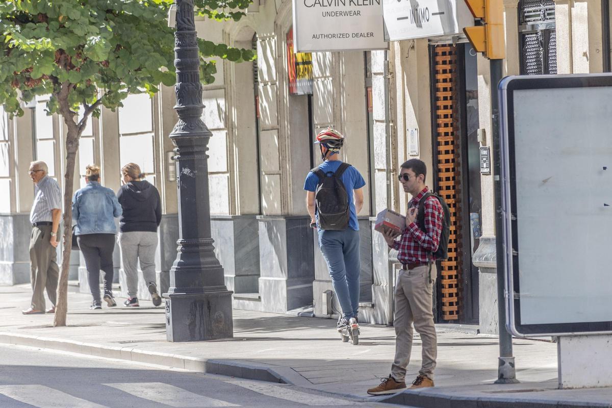Un conductor de patinete eléctrico -con casco- pero circulando sobre la acera en el casco urbano de Orihuela