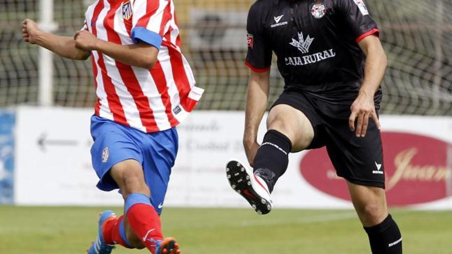 Jacobo despeja un balón en presencia de Óliver Torres.