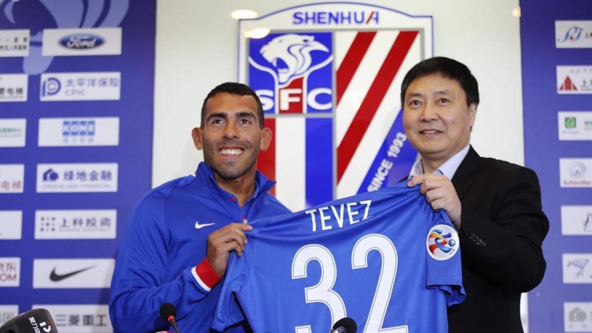 Tevez sostiene una camiseta del Shanghái Shenhua durante su presentación