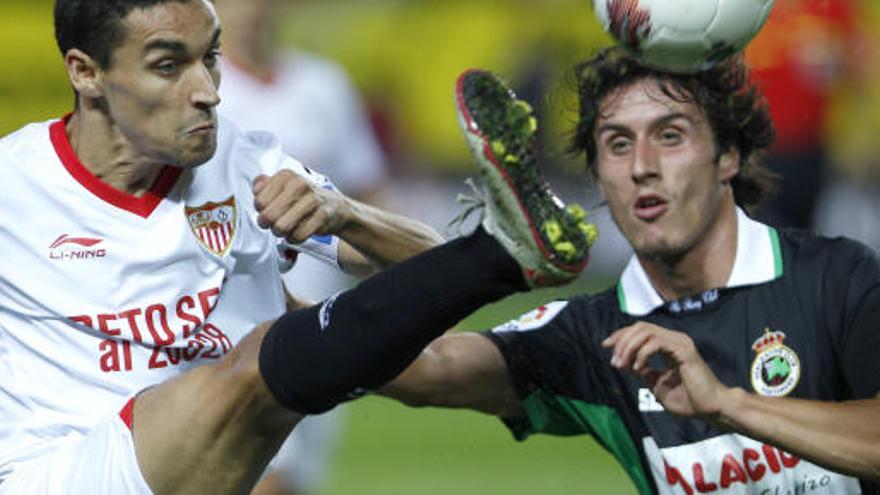 El jugador del Sevilla Jesús Navas disputa un balón con Christian Fernández, del Racing de Santander.