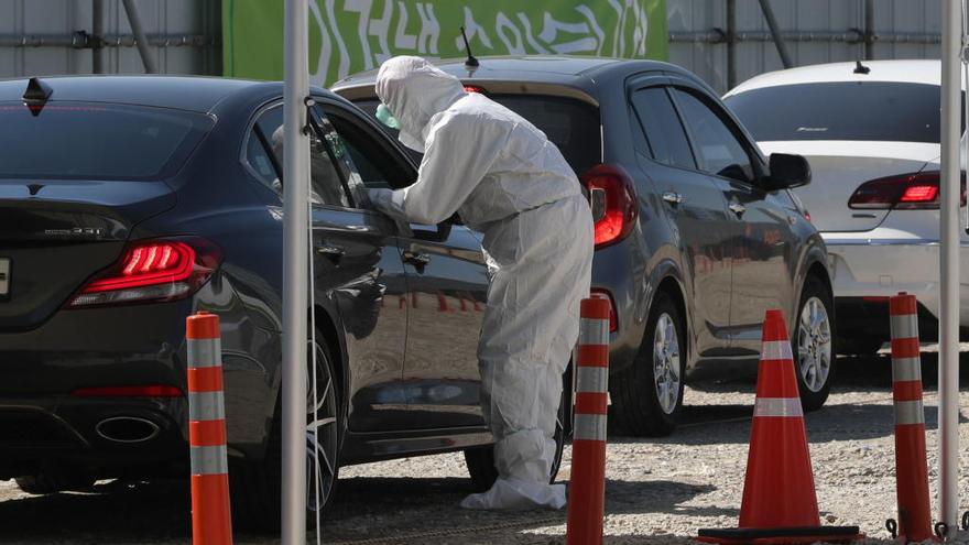 Un sanitario hace el test de coronavirus en un puesto móvil.