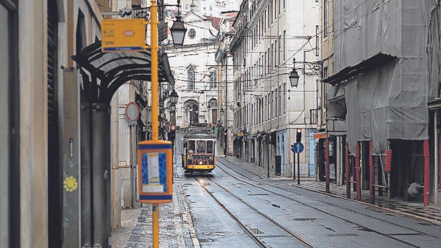 Un tranvía circula por una calle desierta de Lisboa. // Rafael Marchante