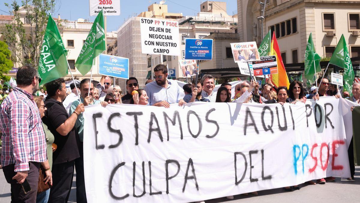 Miembros de Vox sostienen una pancarta contra el PP y el PSOE en la protesta.