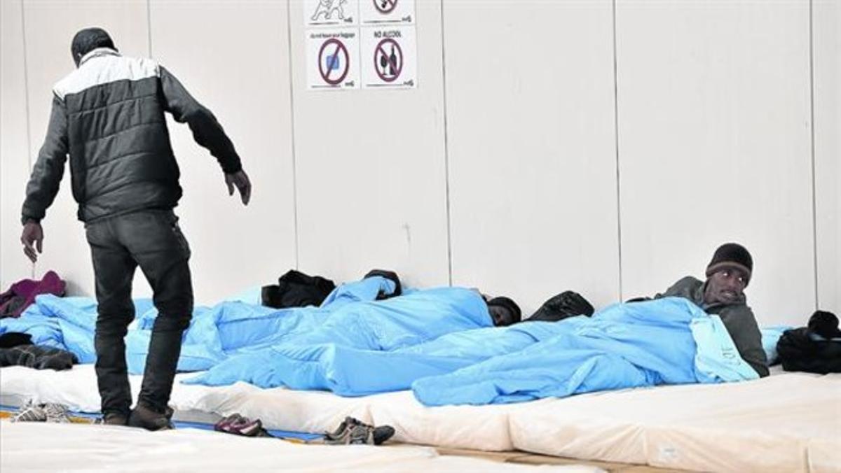 Uns immigrants pernocten enuna nau industrial de Calais. Uns immigrants pernocten enuna nau industrial de Calais.