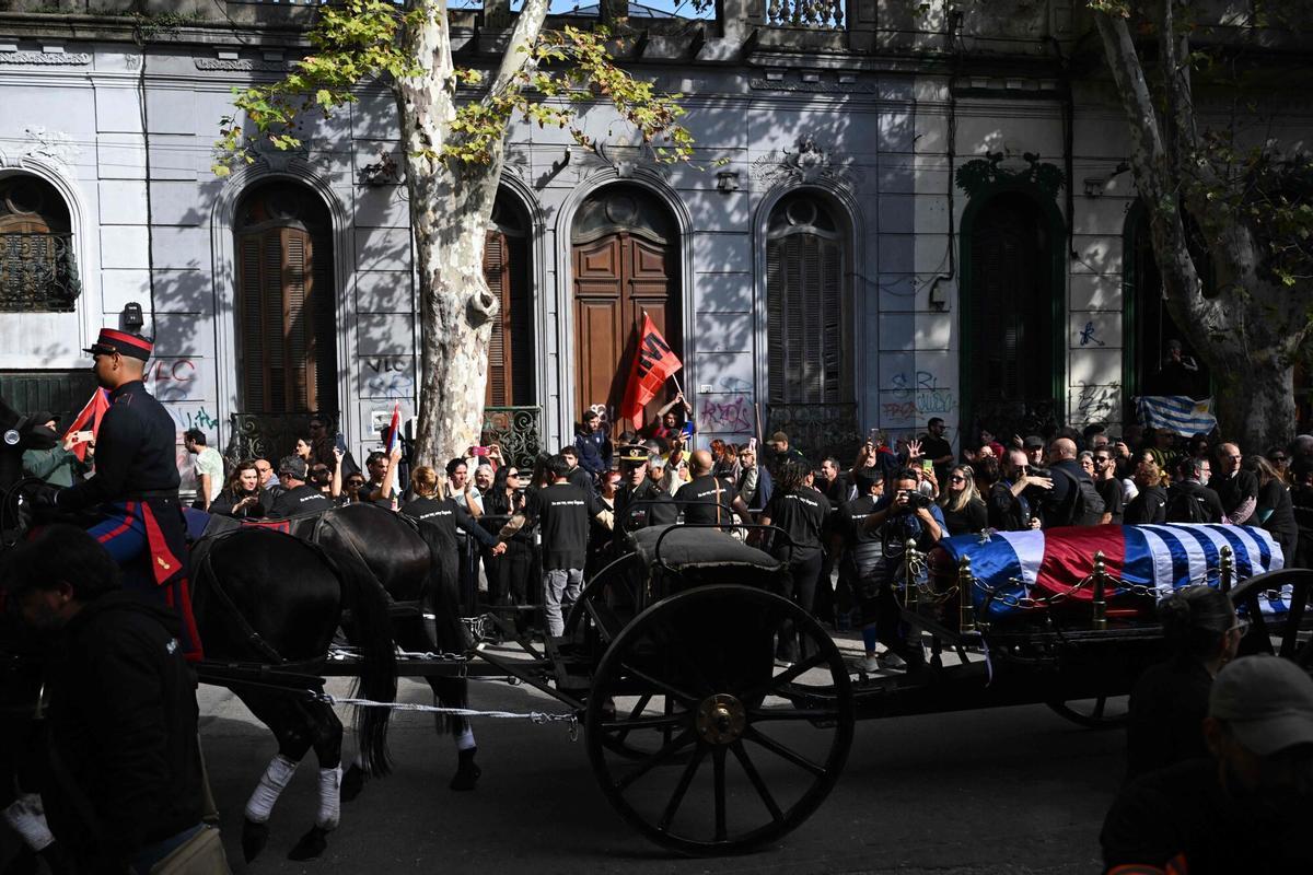 The funeral cortege of Uruguays former President Jose Pepe Mujica makes its way in downtown Montevideo, on May 14, 2025, a day after his death. Mujica, an ex-guerrilla fighter and hero of the Latin American left, died on May 13, 2025 at the age of 89. The humble leader -- who once spent a dozen years behind bars for revolutionary activity -- lost his battle against cancer after announcing in January the disease had spread and he would stop treatment. (Photo by Eitan ABRAMOVICH / AFP)