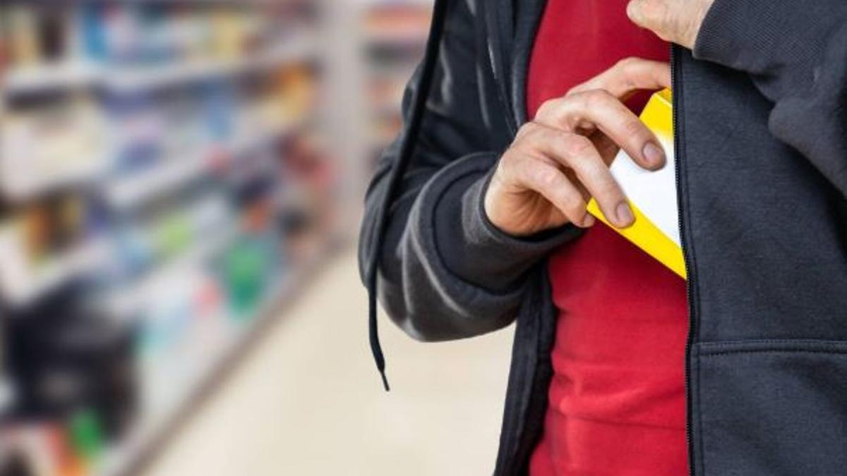 Una persona se introduce un producto dentro de su chaqueta