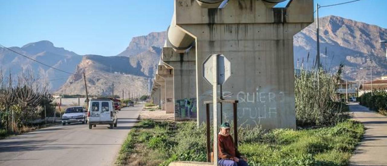 Un agricultor descansa debajo de uno de los pilares del trasvase Tajo-Segura a su paso por la comarca de la Vega Baja.