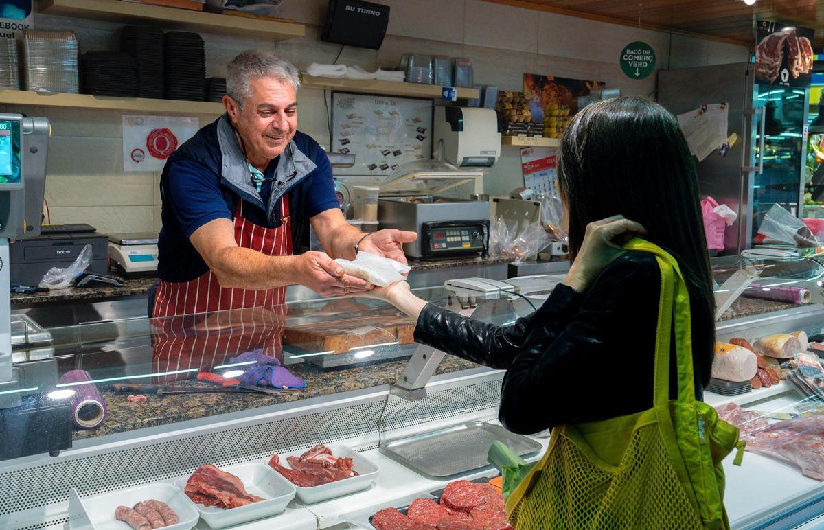 Miquel Hernández, paradista del Mercado Santa Caterina, entrega escalopas envueltas con el nuevo producto a la CEO de Roll'eat.