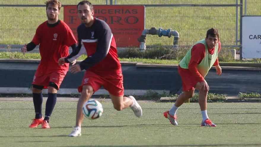 Espolita busca el balón en un entrenamiento del Marino, con Imanol y Riki Navarro tras él.