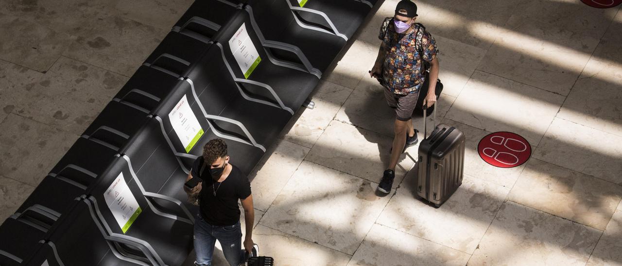 Archivo - Dos personas con maletas en la terminal T4 del Aeropuerto Adolfo Suárez Madrid-Barajas, a 21 de mayo de 2021.