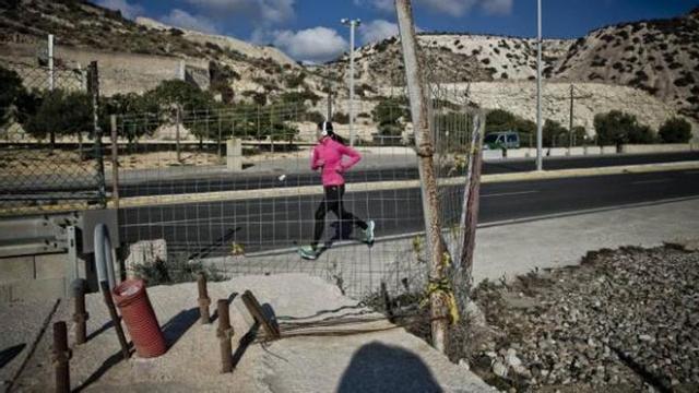 Una joven pasa corriendo junto a los restos del paseo que se inició junto a la carretera de la Cantera, hoy abandonado.