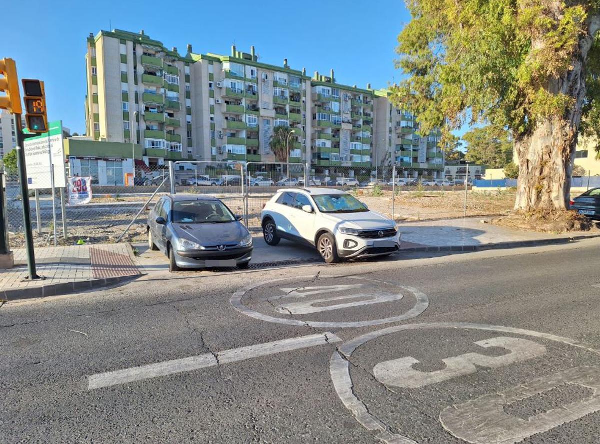 Coches aparcados en la entrada al solar del antiguo Centro de Salud del Palo, el sábado. Interrumpen el paso peatonal a pocos metros de la Policía Local.