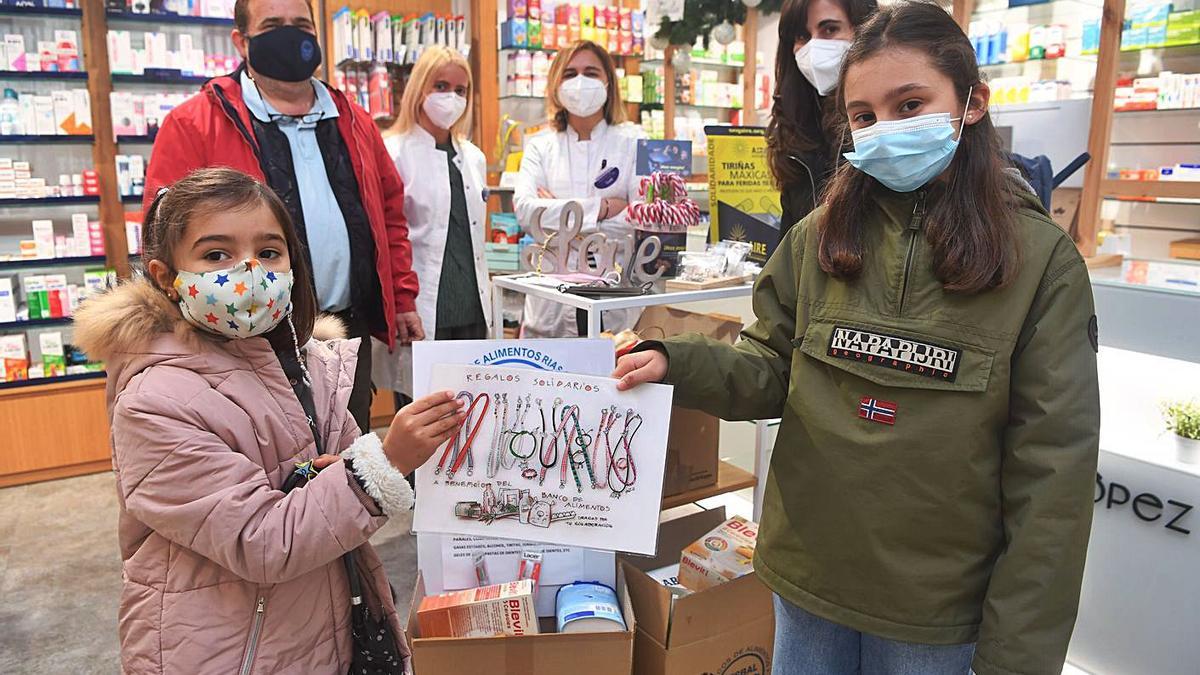 La familia, con representantes del Banco de Alimentos y personal de la farmacia Agrela.   | /CARLOS PARDELLAS