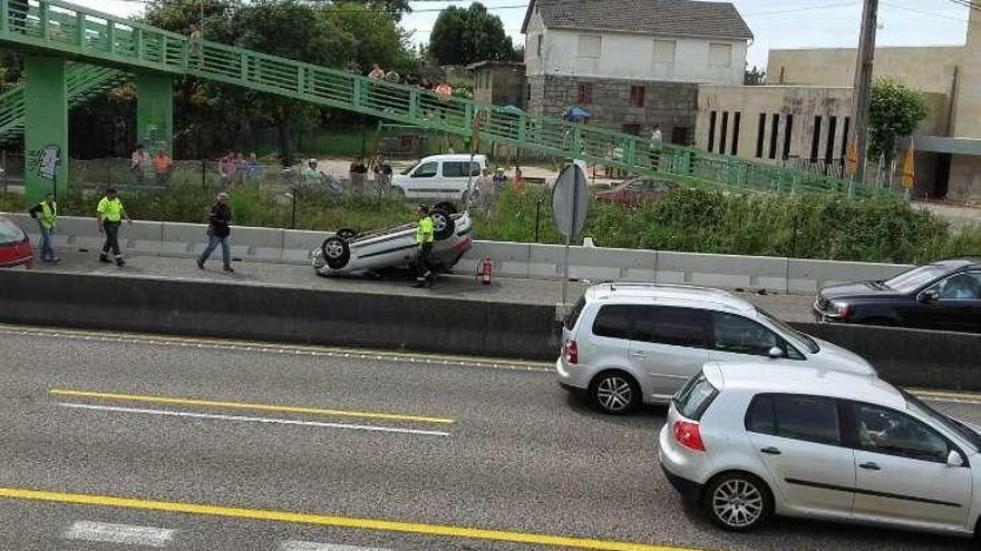 El coche volcado en la AP-9, en Chapela.  // Fdv