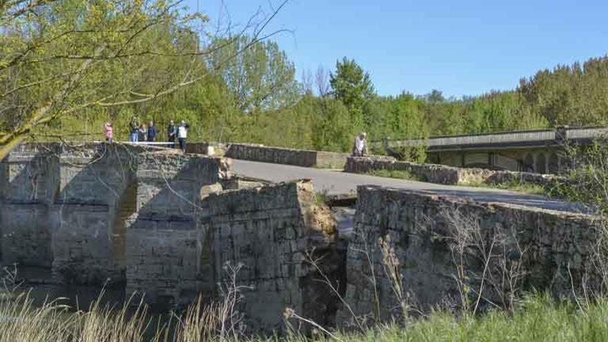 Vecinos y curiosos en el puente de piedra de Castrogonzalo horas después de que se produjera el hundimiento de la cimentación.