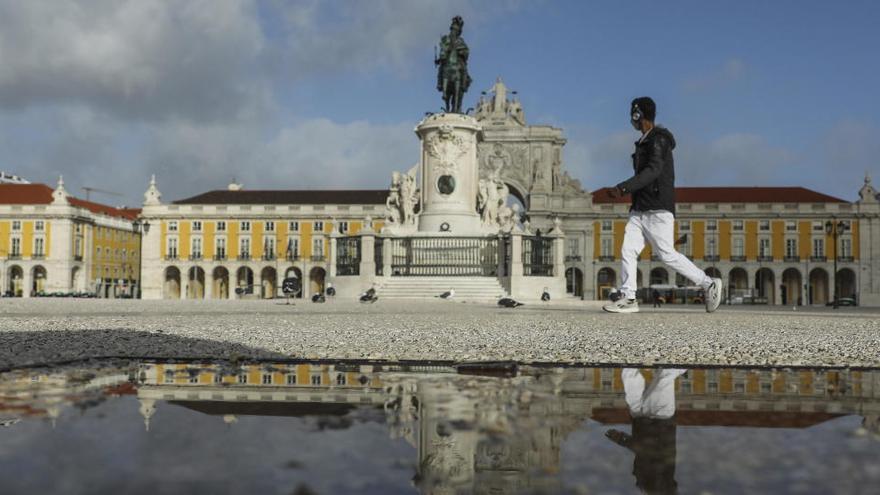 Una persona camina en una plaza de Lisboa.