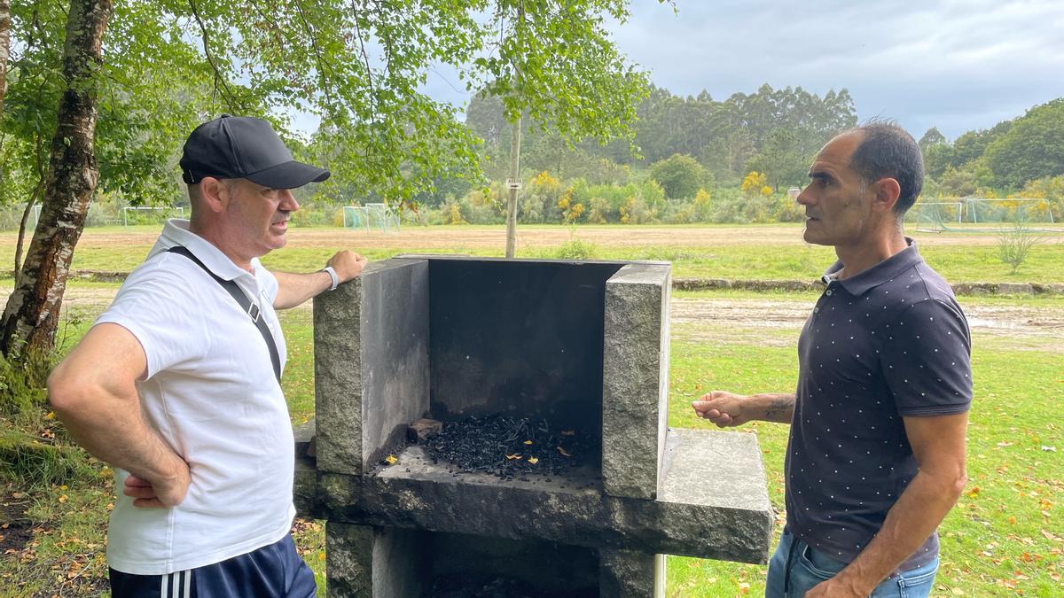 Félix Juncal y Ricardo Verde junto a uno de los asaderos del área recreativa de Chans, en Cela.