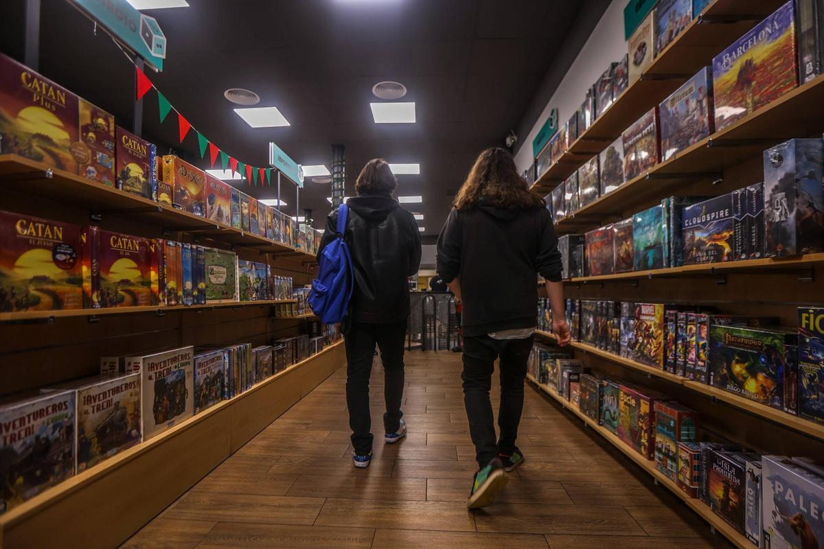 Una pareja camina entre ejemplares de Catán y de Barcelona, novedad de este año, en Gameria, Ausiàs March, 52.
