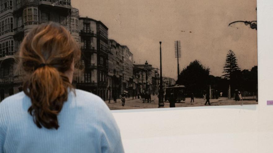 Visitante de la exposición delante de una imagen antigua de plaza de Mina.   | // CAAMAÑO / ROLLER AGENCIA