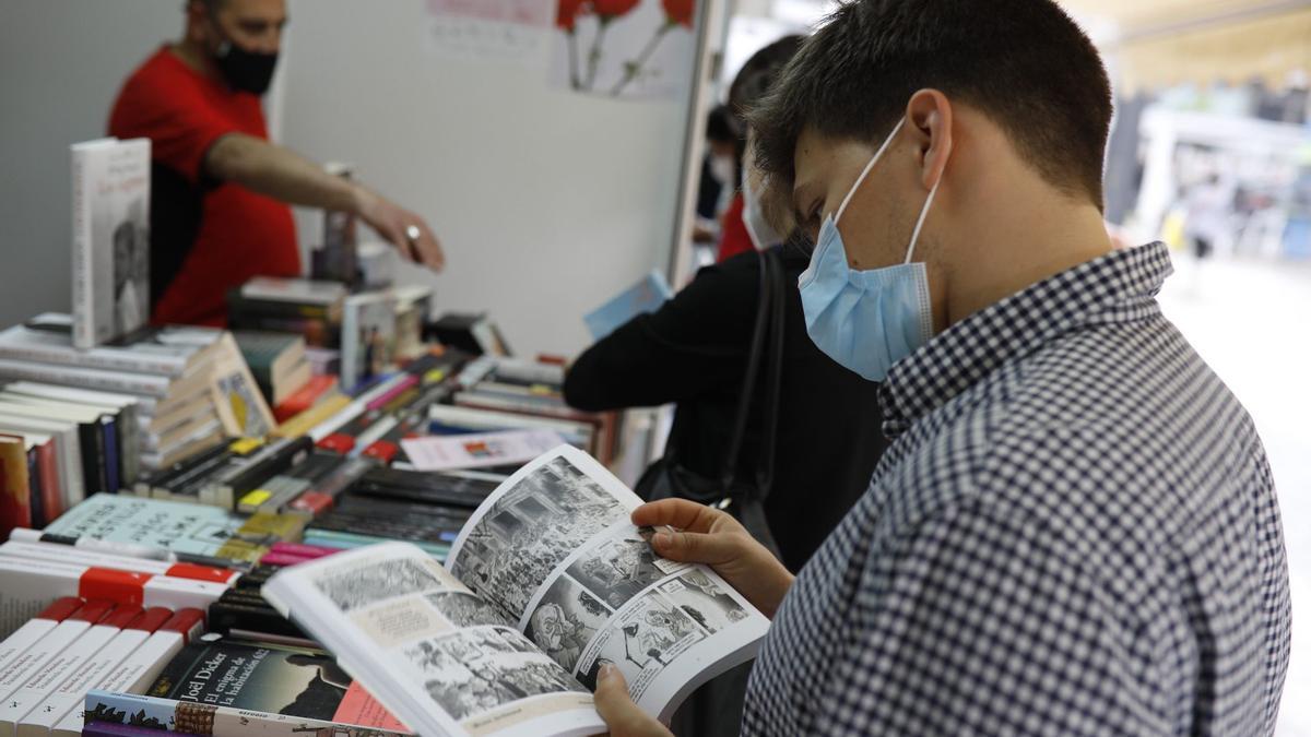 Un joven ojea uno de los ejemplares de la Feria del Libro de Zamora.