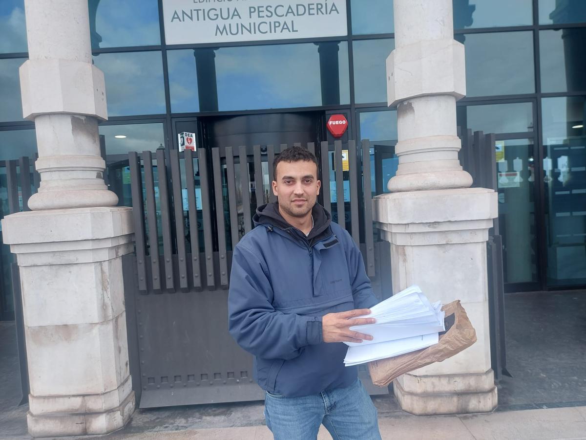 Emilio Herrero, con las firmas recopiladas, antes de registrarlas, a la entrada de la Antigua Pescadería Municipal.