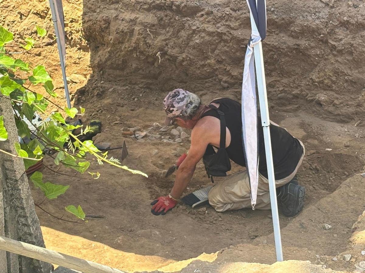 Un peón trabaja limpiando en la zona empedrada que ha salido a la luz en la avenida de Huelva de Badajoz.