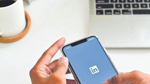 Un hombre abre la aplicación de Linkedin en un móvil.