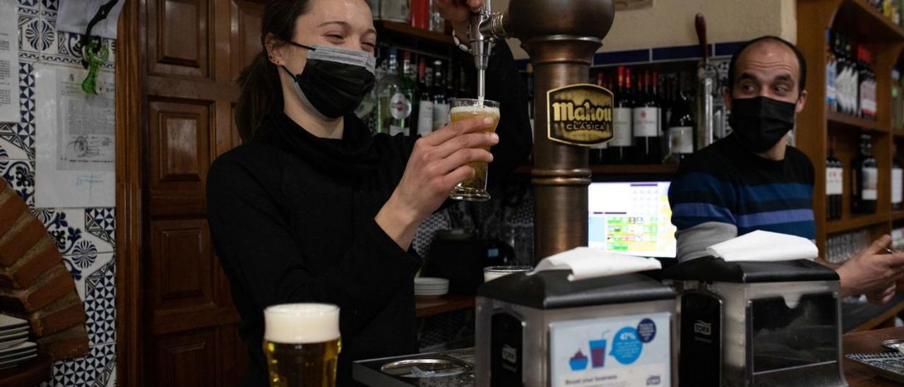 Una camarera sirviendo una caña en un bar de Zamora.