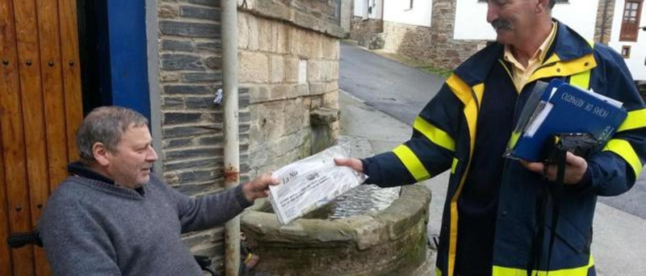 Ramón González entrega un ejemplar de LA NUEVA ESPAÑA a Alfonso Rodríguez en Besullo, ayer.