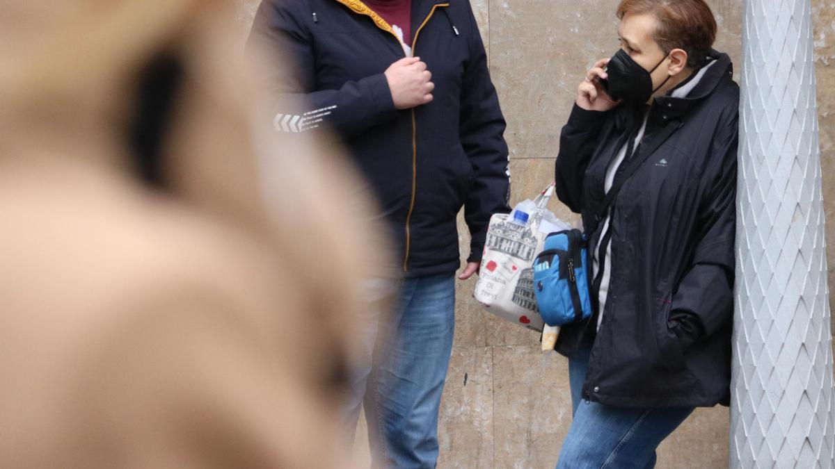 Una dona a l'exterior del Clínic parant per telèfon amb la mascareta posada