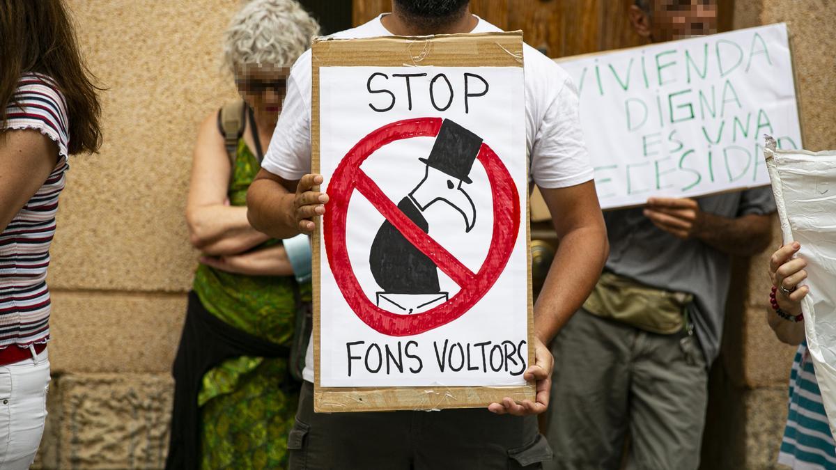 Un manifestante muestra un cartel contra los fondos buitre, en un desahucio en Alicante.
