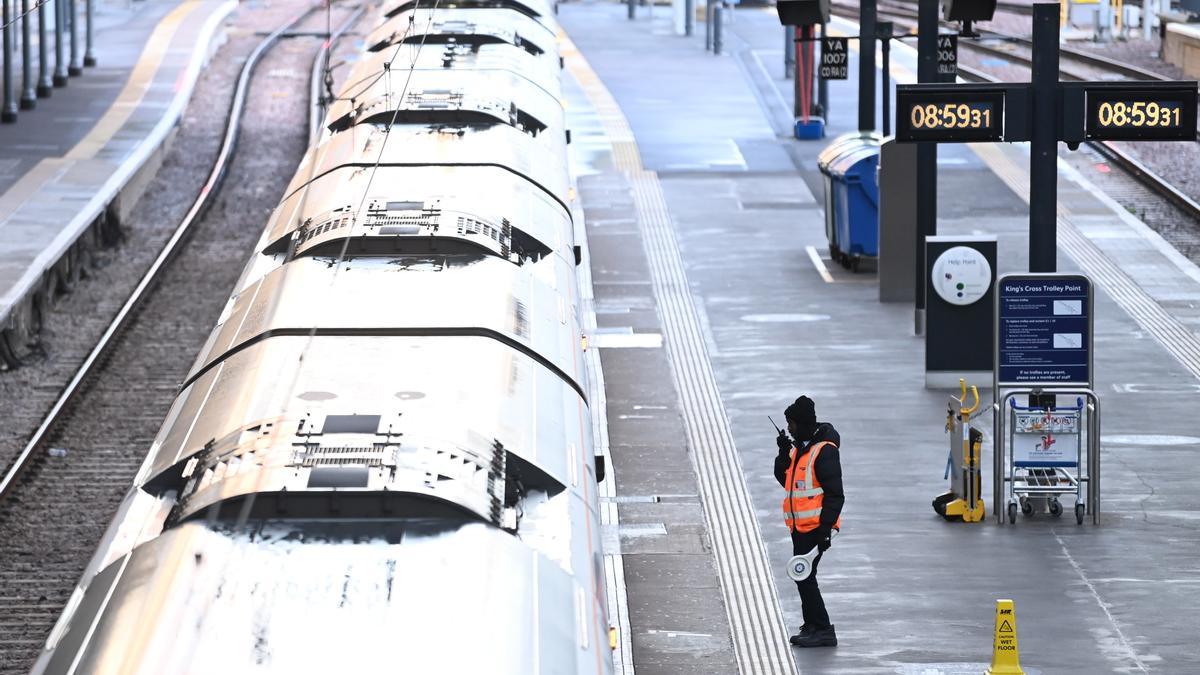 Un empleado aguarda la llegada de un tren en la estación de Kings Cross, este viernes en Londres (Reino Unido).