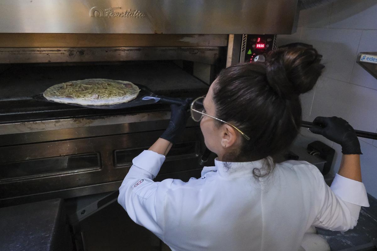 Patrizia di Leo introduce una pizza en el horno en A Casa Mia.