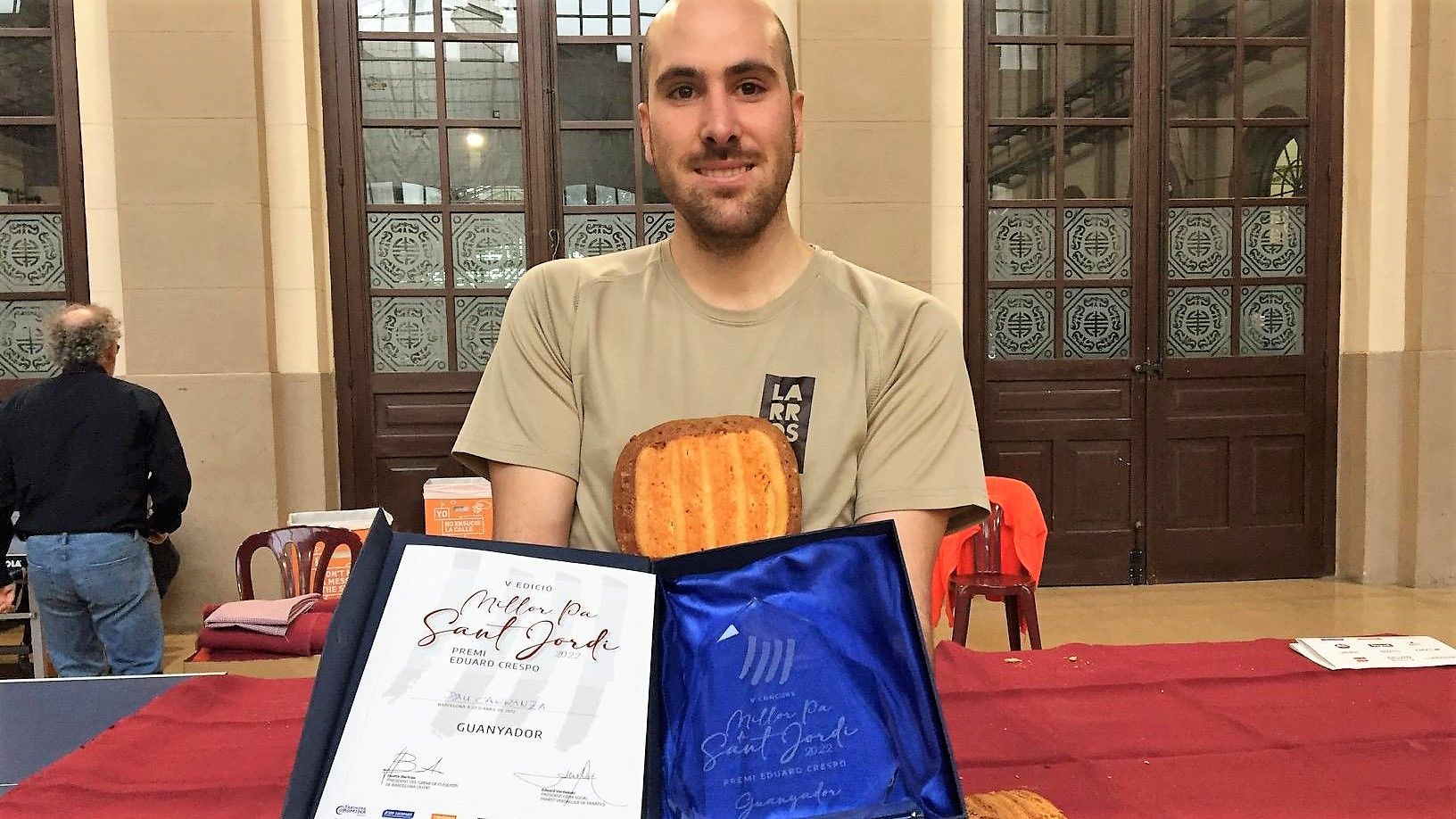 Pau Carranza, de Pastisseria Larrosa (Flix), con su pan de Sant Jordi y los diplomas que lo acreditan como ganador del concurso de este año 2022.