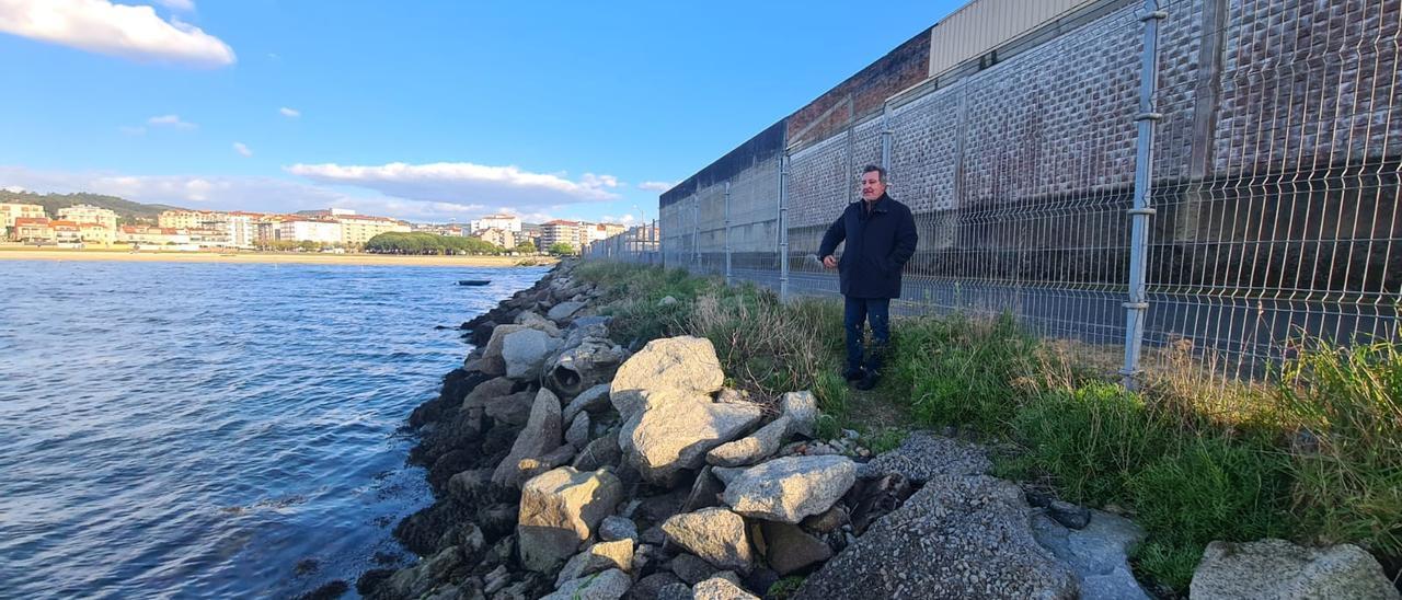 El presidente de los parquistas ante las naves de O Ramal. Al fondo, la playa de Compostela y el centro urbano de Vilagarcía.