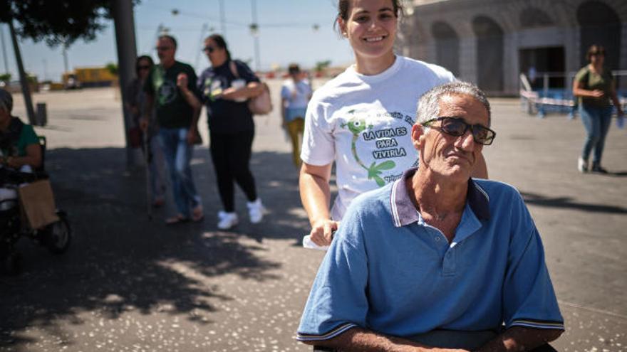 Una cuidadora ayuda a una persona con esclerosis múltiple.