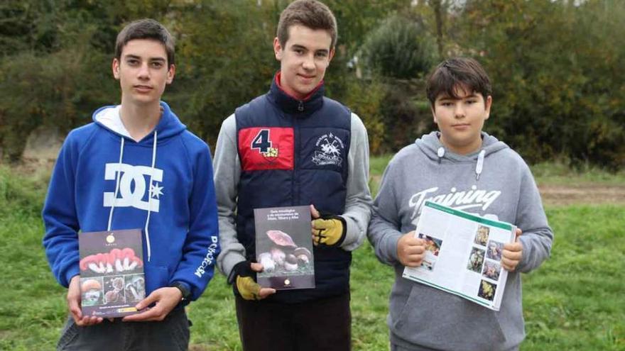 Tres jóvenes de Valer de Aliste, ayer, muestran la publicación sobre las setas alistanas.